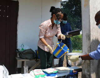 Луиза Абайоми, старший научный сотрудник (Postharvest), Департамент продовольствия и рынков, готовит фуфу для дегустации и показывает конголезской команде, как дозировать нужное количество муки, воды, питательных веществ. Фото: ВПП ООН/Алиса Рахмун