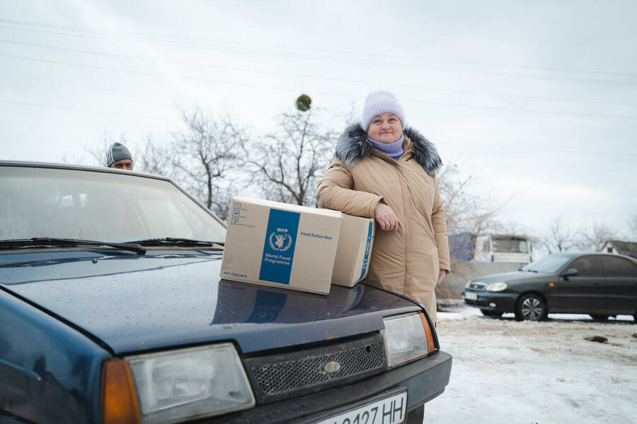 Украинская женщина получает коробку с продовольствием